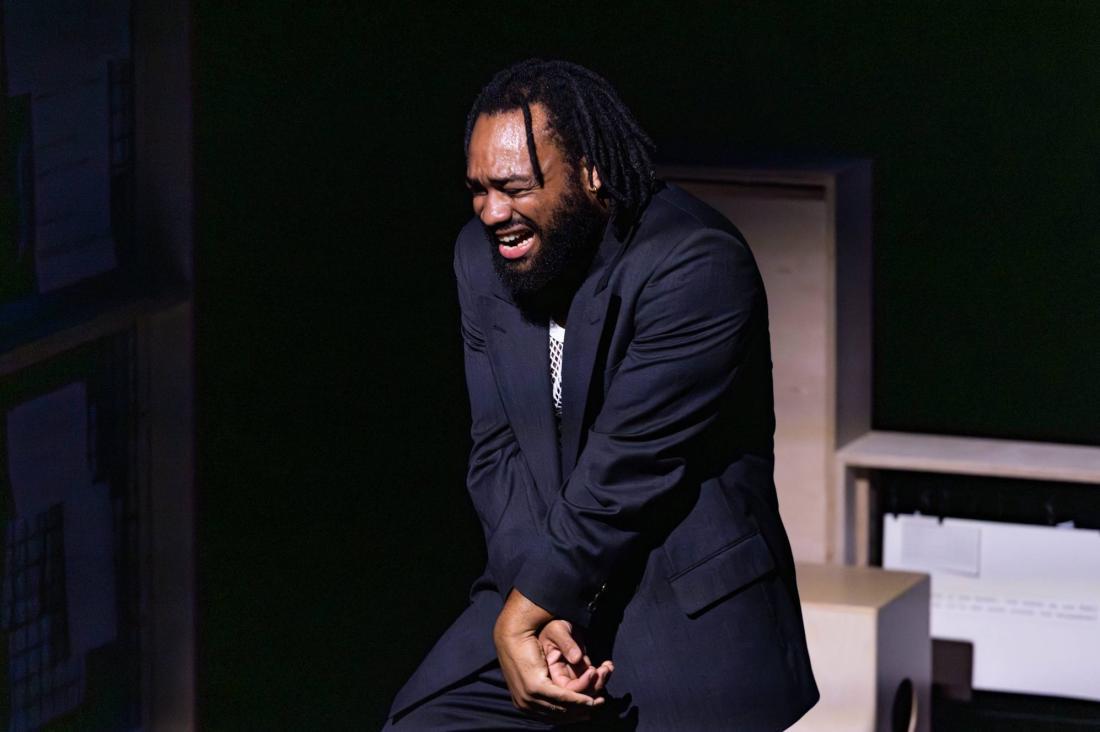 Man standing in pain wearing a black jacket