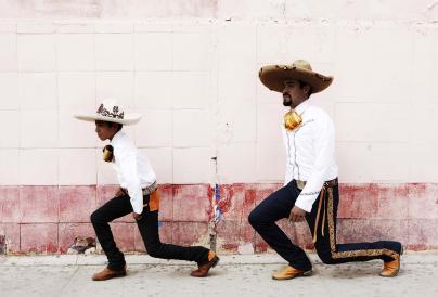 An image of two boys in a sombrero kneeling