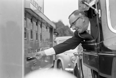 Man posting a letter from a car window. Black and white photo courtesty of The Culture Trust and the Luton News