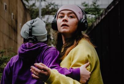 2 female performers with headphones on.