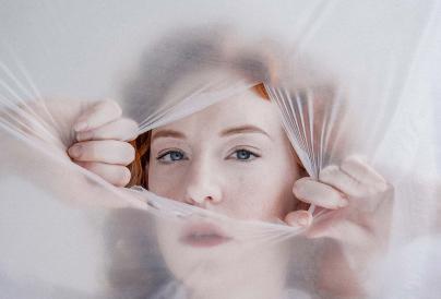 an image of a female peeking through a material